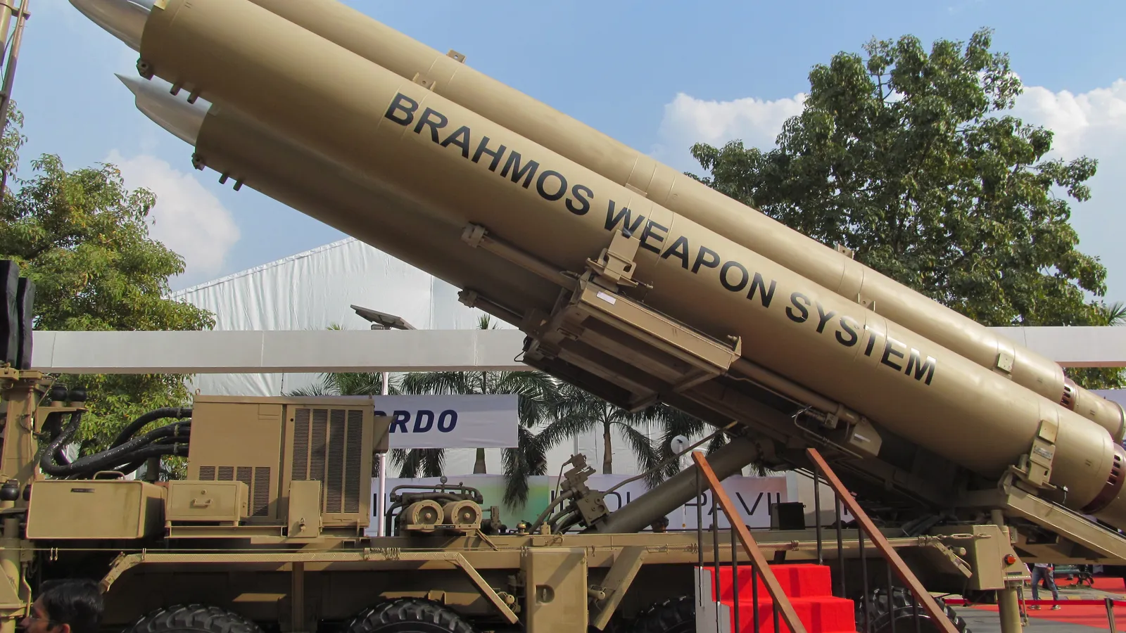BrahMos missile canisters raised on an Indian Army Mobile Autonomous Launcher, with 'BRAHMOS WEAPON SYSTEM' lettering visible on the tubes.