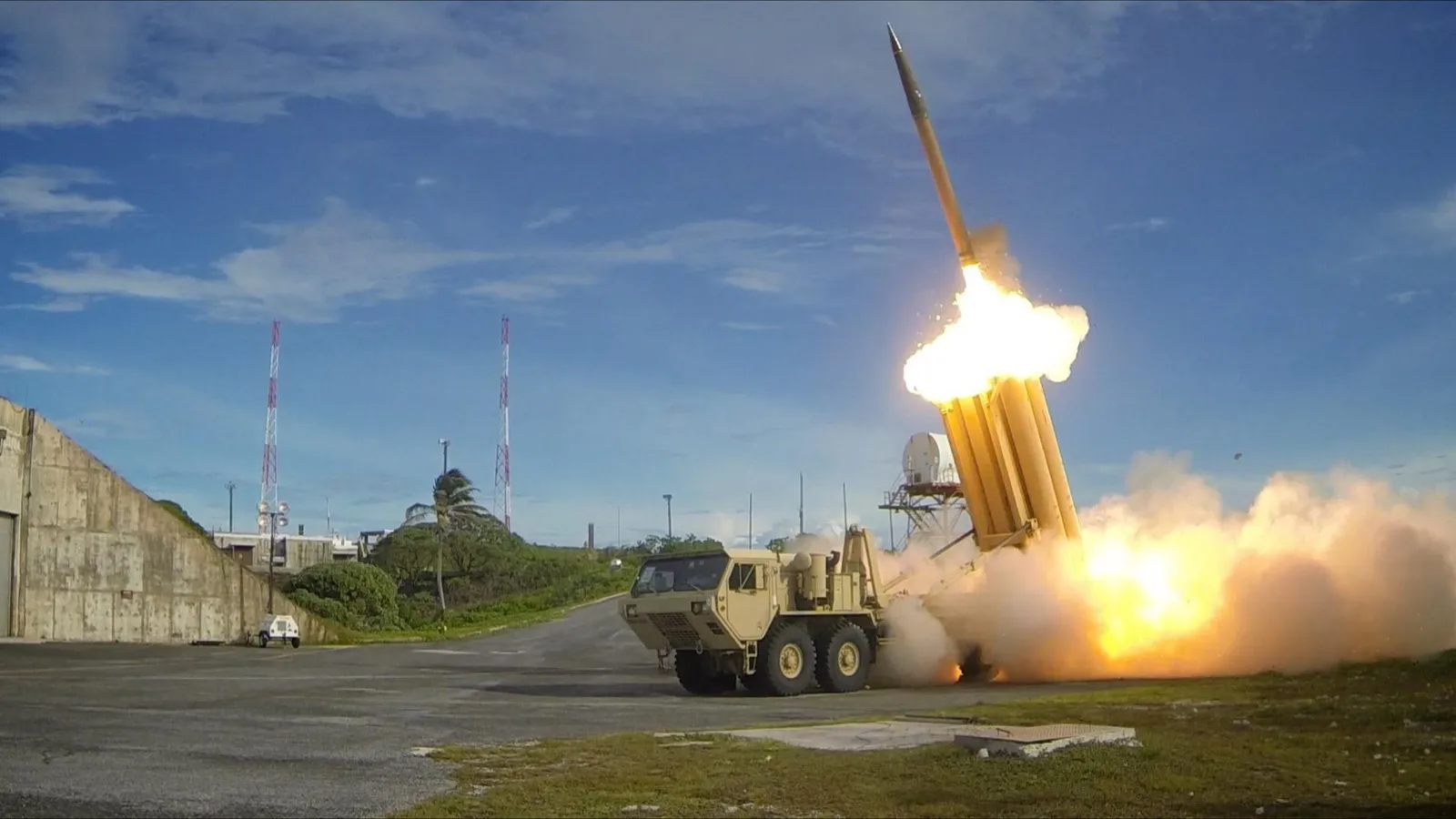 A THAAD interceptor launches from its truck-mounted launcher during an intercept test, trailing a bright exhaust plume.