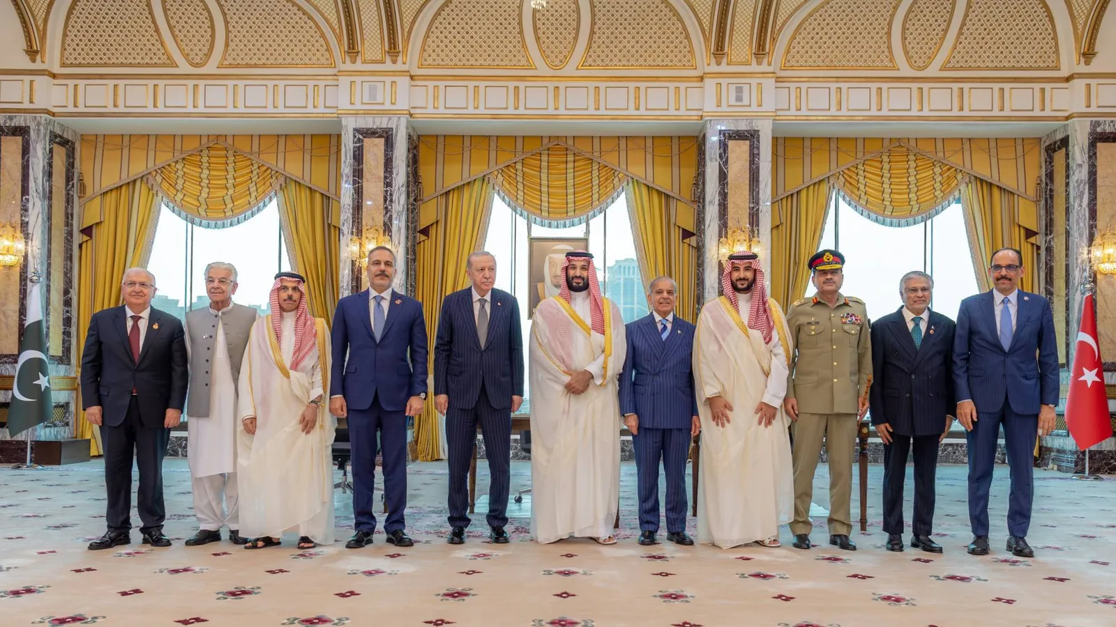 Saudi Crown Prince Mohammed bin Salman, Turkish President Recep Tayyip Erdogan and Pakistani Prime Minister Shehbaz Sharif stand with their foreign ministers, defence ministers and military chiefs in a gilded hall of Al-Safa Palace in Makkah after signing the Makkah Joint Defence Agreement, with the Pakistani and Turkish flags at either end of the line.