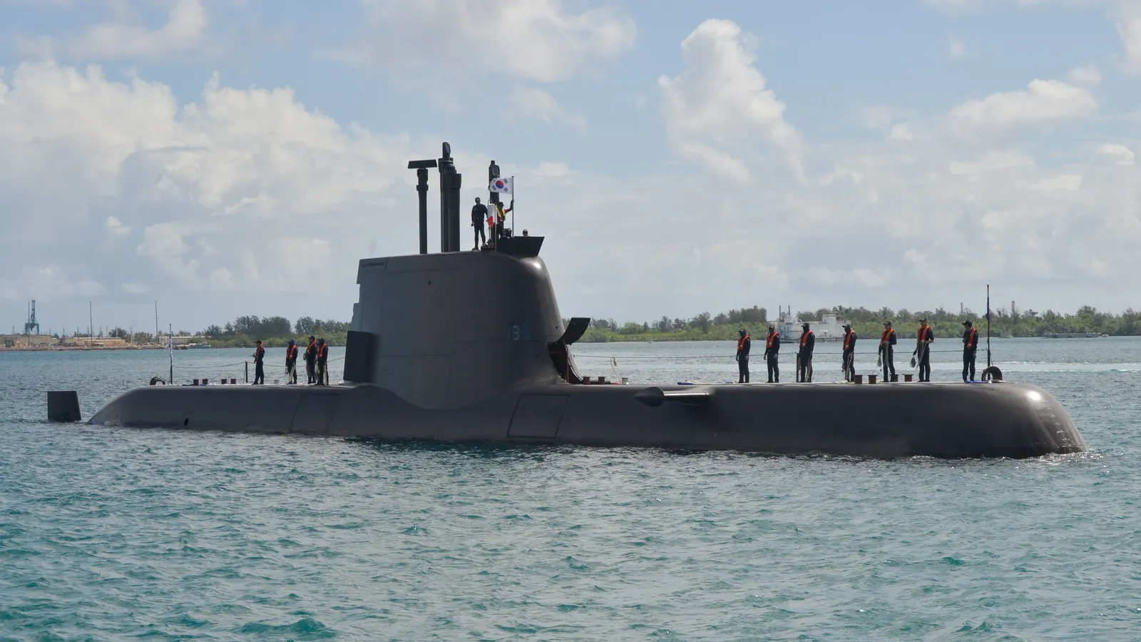 The South Korean Navy Type 214 submarine ROKS Yun Bonggil surfaced in harbour waters with crew standing on its deck.
