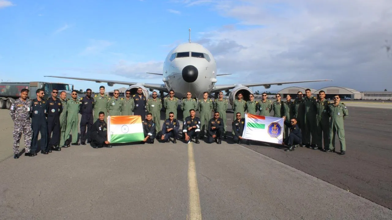 Indian Navy P-8I aircrew pose with the national flag in front of their aircraft on the tarmac after arriving in Hawaii for RIMPAC 2026.