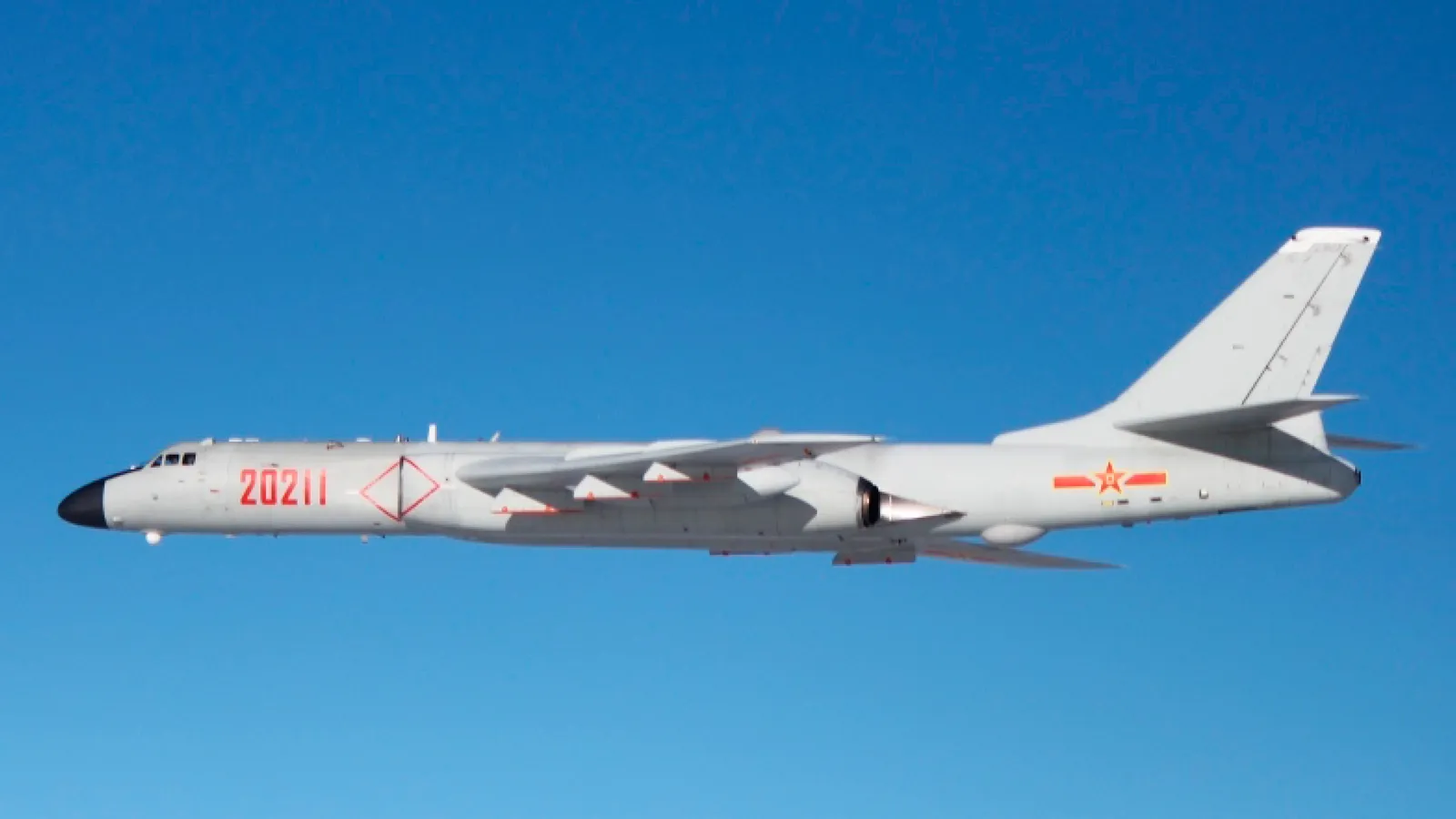A Chinese PLA Air Force H-6K bomber, tail number 20211, in flight against a clear blue sky, photographed by Japan's Joint Staff Office during a 2015 intercept.
