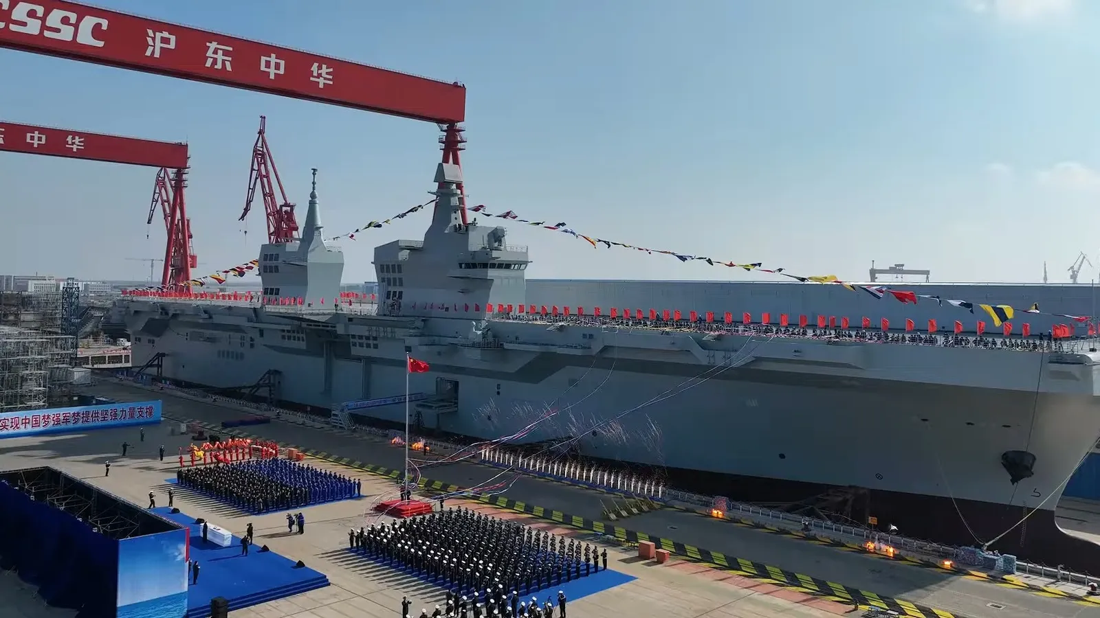The Type 076 amphibious assault ship Sichuan, dressed in signal flags and showing its twin-island superstructure and full-length flight deck, at its launch ceremony at the Hudong-Zhonghua shipyard in Shanghai.